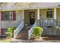 Brick house with white porch, steps, and rocking chairs at 3520 Tom Brewer Rd, Loganville, GA 30052