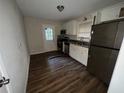 Eat-in kitchen with white cabinets, stainless steel appliances, and wood-look flooring at 214 Thornton Sw St, Atlanta, GA 30315