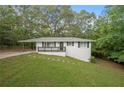 White brick ranch house with carport, black railings, and landscaped yard at 6650 Queen Mill Se Rd, Mableton, GA 30126