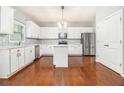 Modern kitchen featuring white cabinets, stainless steel appliances, and hardwood floors at 2166 Leatherstone Dr, Powder Springs, GA 30127