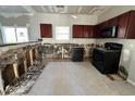 Kitchen mid-renovation with dark cabinets, black appliances, and tiled floor. Needs finishing touches at 6415 Grey Fox Way, Riverdale, GA 30296