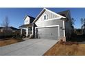 Gray siding two-story house with a two-car garage and landscaping at 231 Strawberry Ln, Woodstock, GA 30189