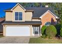 Tan and brick two-story house with a double-car garage at 2080 Racquet Club Cir, Lawrenceville, GA 30043