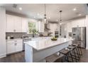 Modern kitchen with white cabinets, quartz countertops, and a large island at 7675 Homer Dr, Cumming, GA 30028