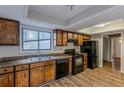 Kitchen with wood cabinets, black appliances, and vinyl flooring at 9887 Live Oak Ct, Douglasville, GA 30135