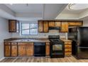 Kitchen with wood cabinets, black appliances, and a double sink at 9887 Live Oak Ct, Douglasville, GA 30135
