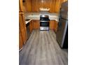 Kitchen features wood cabinets, granite counters and gray vinyl flooring at 5621 Zanola Sw Dr, Mableton, GA 30126