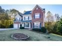 Two-story brick home with three-car garage and landscaped lawn at 138 Slippery Rock Ct, Villa Rica, GA 30180