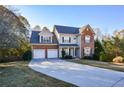 Two-story brick home with three-car garage and landscaped lawn at 138 Slippery Rock Ct, Villa Rica, GA 30180