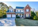Two-story brick home with three-car garage and landscaped lawn at 138 Slippery Rock Ct, Villa Rica, GA 30180