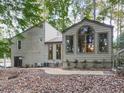 Back of house with sunroom and deck overlooking wooded area at 3771 Club Nw Dr, Kennesaw, GA 30144