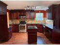 Kitchen with dark wood cabinets, granite counters, and island at 3668 Deer Springs Pkwy, Ellenwood, GA 30294