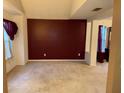 Spacious living room with burgundy walls and carpet at 3668 Deer Springs Pkwy, Ellenwood, GA 30294
