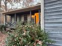 Front porch with a light fixture and shrubs, leading to the entrance of a house at 5200 Beechwood Forest Ct, Lithonia, GA 30038