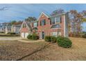 Brick two-story house with a two-car garage, and neat landscaping at 915 Lake Dr, Snellville, GA 30039