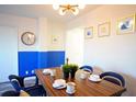 Dining area with wood table, blue chairs, and a modern light fixture at 215 Piedmont Ne Ave # 1905, Atlanta, GA 30308