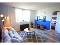 Bright living room with blue accent wall, comfy sofa, and wood-look floors at 215 Piedmont Ne Ave # 1905, Atlanta, GA 30308