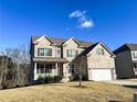 Two-story brick home with a three-car garage and manicured lawn at 7860 Bristol Valley Dr, Cumming, GA 30028