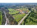 Aerial view showing stables, paddocks, and creek at 2431 Perkerson Mill Rd, Austell, GA 30106