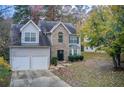 Two-story house with stone accents, two-car garage, and landscaped yard at 3579 Oakshire Se Way, Atlanta, GA 30354