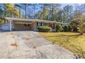 Ranch home with covered carport and mature trees at 6677 Songwood Dr, Austell, GA 30168