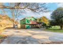 Side view of a ranch home with green and brown siding and a large yard at 3526 Macedonia Rd, Powder Springs, GA 30127