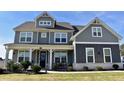 Two story home with gray siding, white trim, and a large front yard at 100 Leveret Rd, Locust Grove, GA 30248