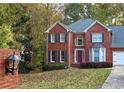 Two-story brick home with a red door and landscaping at 4761 Habersham Way, Conyers, GA 30094