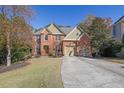 Brick house with a three-car garage and beautifully landscaped lawn at 3423 Mulberry Lane Ct, Dacula, GA 30019