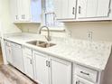 White kitchen with quartz countertops and new sink at 2870 Aunt Pitty Pat Ln, Douglasville, GA 30135