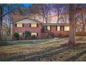 Charming brick two-story home at dusk with a welcoming front yard and walkway at 5620 Forest Dr, Acworth, GA 30102