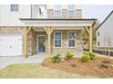 Covered front porch with brick columns and a blue front door at 3952 Adler Cir, Buford, GA 30519