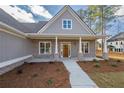 Inviting front porch with brick columns and a wooden door at 312 Brook Hollow Ln, Loganville, GA 30052