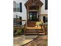 Inviting front porch with wooden stairs, pumpkins, and plants at 5673 Yorktown Rd, Douglasville, GA 30135