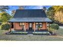 Front view of a charming log cabin home with a welcoming porch at 923 Pine Cir, Woodstock, GA 30189