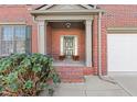 Covered front porch with brick columns and a charming entry door at 727 Pear Grove Pl, Marietta, GA 30066