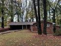 Brick ranch house with carport, surrounded by mature trees at 2820 Arlington Rd, Atlanta, GA 30344