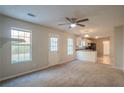 Open living space with kitchen views and neutral carpet at 6390 Alford Cir, Lithonia, GA 30058