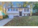 Front view of a house with a green lawn and trees at 2076 Scarbrough Dr, Stone Mountain, GA 30088