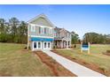Two-story home with gray siding, brick accents, and a landscaped lawn at 236 Ruthe Cvs, Locust Grove, GA 30248