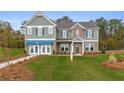 Two-story home with gray siding, brick accents, and a landscaped lawn at 236 Ruthe Cvs, Locust Grove, GA 30248