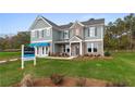 Two-story home with gray siding, brick accents, and a landscaped lawn at 236 Ruthe Cvs, Locust Grove, GA 30248