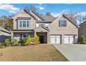 Two-story brick home with a three-car garage and landscaped lawn at 622 Denali Dr, Mableton, GA 30126