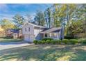 Gray house with a two-car garage, and lush green lawn at 5382 Kemper Pl, Stone Mountain, GA 30088