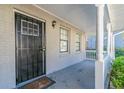 Front porch with white columns, brick exterior, and black security door at 5382 Kemper Pl, Stone Mountain, GA 30088