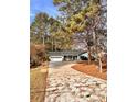 Ranch style home with attached garage, long driveway, and mature trees surrounding the property at 2815 Highway 20 Se, Conyers, GA 30013