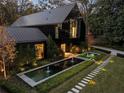Modern home with black exterior, long water feature, and stone pathway at night at 2716 Ridgewood Nw Rd, Atlanta, GA 30327