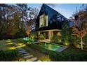 Modern home with black exterior, long water feature, and stone pathway at night at 2716 Ridgewood Nw Rd, Atlanta, GA 30327