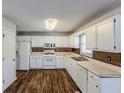 White kitchen with wood-look flooring, white cabinets, and stainless steel appliances at 271 Kings Walk, Douglasville, GA 30134