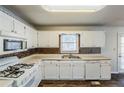 White kitchen with wood-look flooring, white cabinets, and stainless steel appliances at 271 Kings Walk, Douglasville, GA 30134